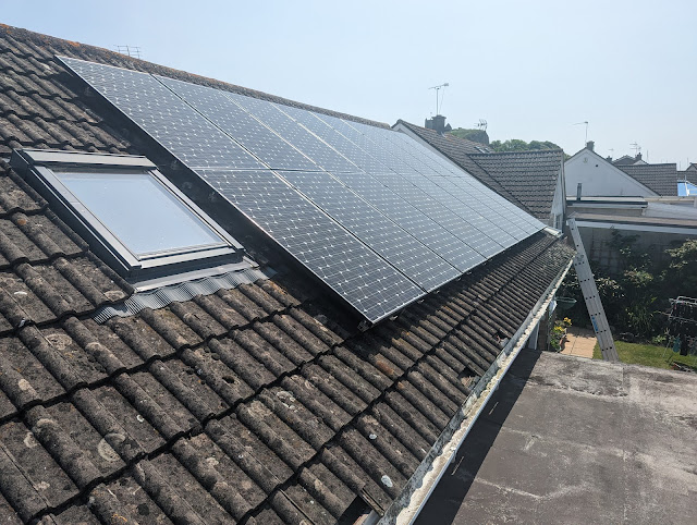 Solar panels on a rooftop with a sunny backdrop.